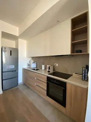 a kitchen with white cabinets and a black appliance at Verde 18 in Sajmište