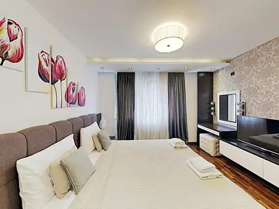a bedroom with a large bed and a television at ETNOGRAF in Belgrade