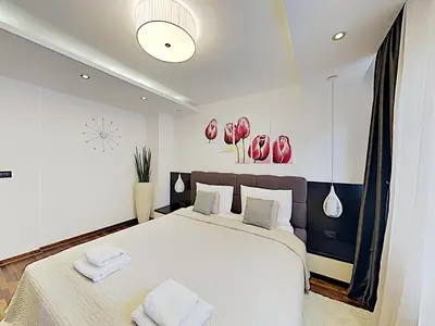 a bedroom with a large bed with two towels on it at ETNOGRAF in Belgrade