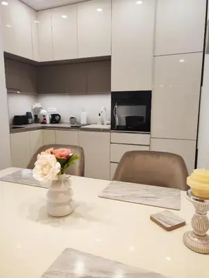 a white kitchen with a table with a vase of flowers at Kalemegdan Park Residence - new luxury apartment in Belgrade