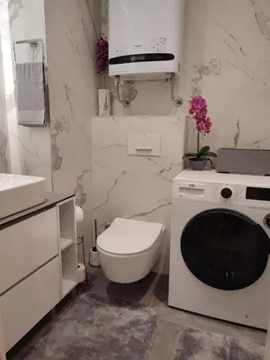 a white bathroom with a toilet and a washing machine at Kalemegdan Park Residence - new luxury apartment in Belgrade