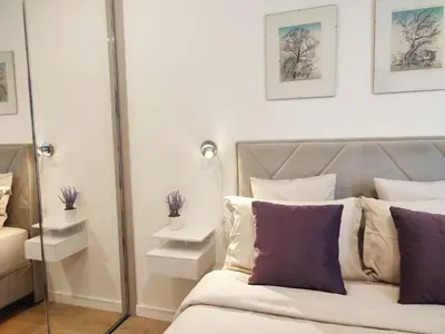 a bedroom with a bed with purple and white pillows at Kalemegdan Park Residence - new luxury apartment in Belgrade