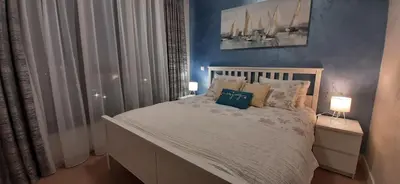 a bedroom with a large bed with two lamps on it at GIGI Apartment in Belgrade