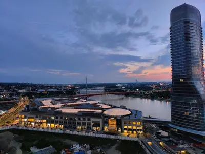 a tall building next to a river and a city at GIGI Apartment in Belgrade