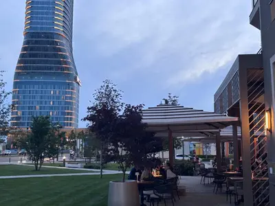 a group of people sitting at tables in a park at GIGI Apartment in Belgrade