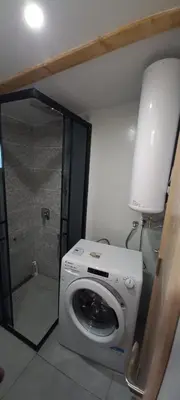 a washing machine in a bathroom with a shower at Island Ada in Čukarica