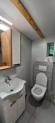 a bathroom with a white toilet and a sink at Island Ada in Čukarica