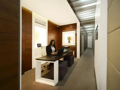 a woman sitting at a desk with a laptop at Eden Garden Suites in Belgrade