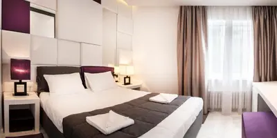 a hotel room with a large bed and a window at Eden Garden Suites in Belgrade