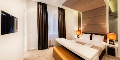 a hotel room with a bed and a large window at Eden Garden Suites in Belgrade