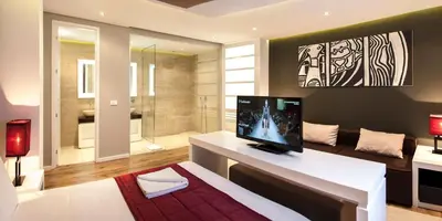 a living room with a television on a white table at Eden Garden Suites in Belgrade