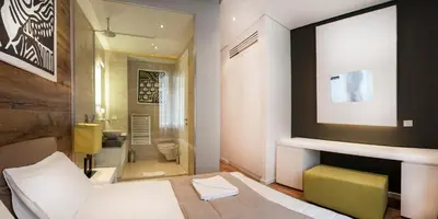 a hotel room with a bed and a bathroom at Eden Garden Suites in Belgrade
