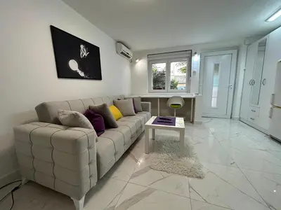 a living room with a white couch and a table at Tesla in Belgrade