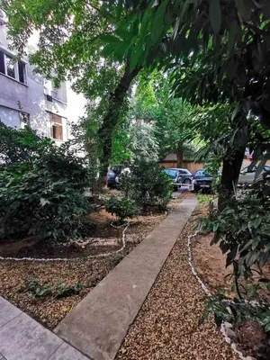 a sidewalk in front of a building with trees at Tesla in Belgrade