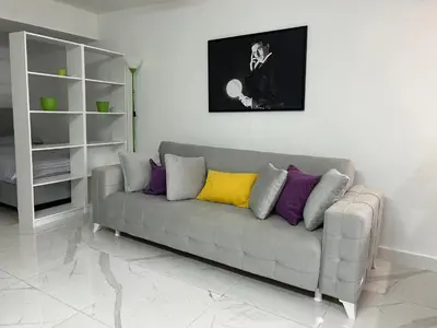 a living room with a gray couch with colorful pillows at Tesla in Belgrade