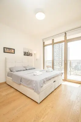 a white bedroom with a large bed and a large window at Belgrade Waterfront Nimax in Sajmište