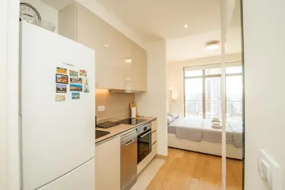 a kitchen with a refrigerator and a bed in a room at Belgrade Waterfront Nimax in Sajmište