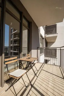 a balcony with a table and chairs on a building at Belgrade Waterfront Nimax in Sajmište