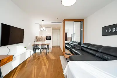 a living room with a black leather couch and a flat screen tv at West 21 Tower in Fontana