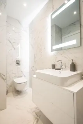 a white bathroom with a sink and a toilet at West Tower Luxury in Fontana