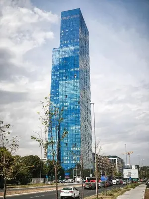 a tall glass building with cars parked in front of it at West Tower Luxury in Fontana