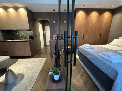 a bedroom with a large bed and a kitchen at Sima City Center in Belgrade