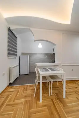 a kitchen with a white table and a white refrigerator at Port 1 in Belgrade