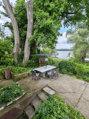 a picnic table and chairs with a view of the water at Varljivo leto, Fruska gora in Čortanovci