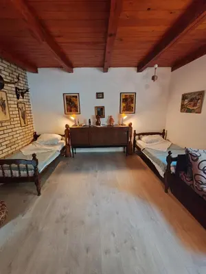 two beds in a large room with wooden ceilings at Varljivo leto, Fruska gora in Čortanovci