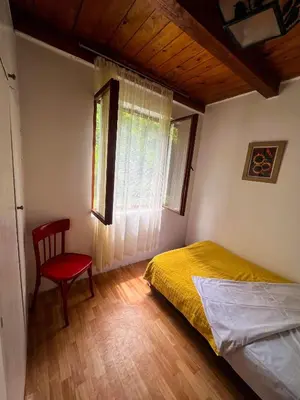 a bedroom with a bed and a chair and a window at Varljivo leto, Fruska gora in Čortanovci