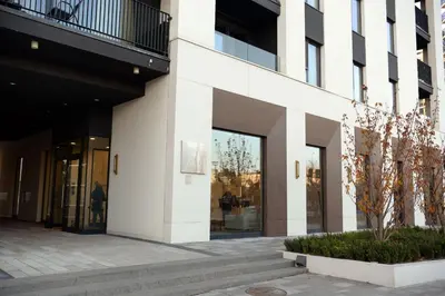 a building with large windows and a courtyard at Apartman Julija in Sajmište