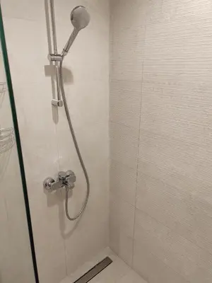 a shower with a shower head in a bathroom at Apartman Julija in Sajmište