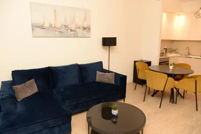 a living room with a blue couch and a table at Apartman Julija in Sajmište