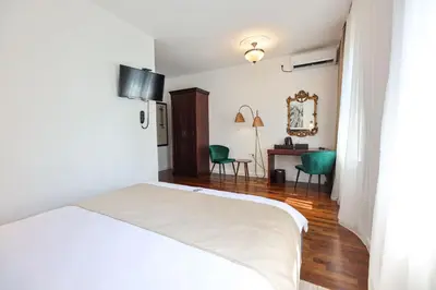a bedroom with a white bed and a desk at Villa 1927 in Belgrade