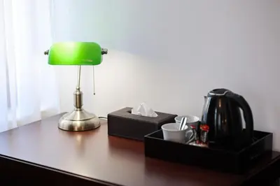 a green lamp sitting on top of a wooden desk at Villa 1927 in Belgrade