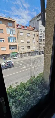 a window with a view of a street with buildings at Villa 1927 in Belgrade