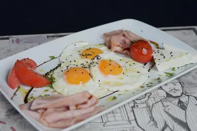 a plate of eggs and tomatoes on a table at Villa 1927 in Belgrade