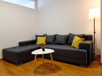 a black couch with yellow pillows and a table at Euforia apartment in Novi Beograd