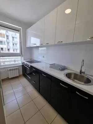 a kitchen with white cabinets and a sink and a window at Euforia apartment in Novi Beograd