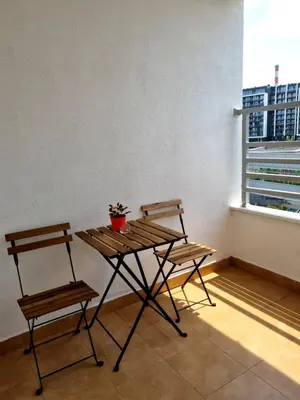 a table and two chairs in a room with a window at Euforia apartment in Novi Beograd