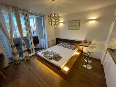 a bedroom with a bed and a large window at Hedonic Studio in Belgrade