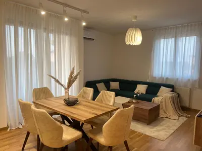 a living room with a table and a couch at Luxe Living Modern Apartment Stara Pazova in Stara Pazova