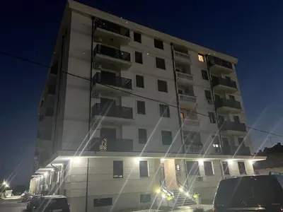 a tall building with cars parked in front of it at Luxe Living Modern Apartment Stara Pazova in Stara Pazova