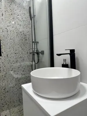 a white sink in a bathroom with a shower at Angelo S in Belgrade