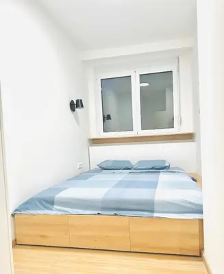 a bed in a white room with a window at Angelo S in Belgrade