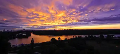 a sunset over a river with a cloudy sky at Angelo S in Belgrade