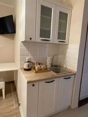 a kitchen with white cabinets and a sink at Airport Apartments Alexandra in Surčin