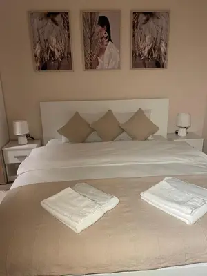 a bedroom with a bed with two towels on it at Airport Apartments Alexandra in Surčin