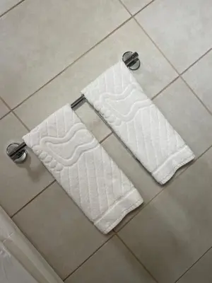 a pair of towels on the floor of a bathroom at Airport Apartments Alexandra in Surčin