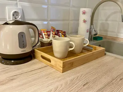 a coffee maker and two coffee cups on a cutting board at Airport Apartments Alexandra in Surčin